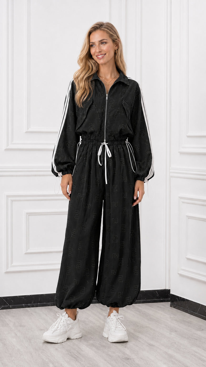 Front view of woman wearing a black zip-up track jumpsuit with white side stripes