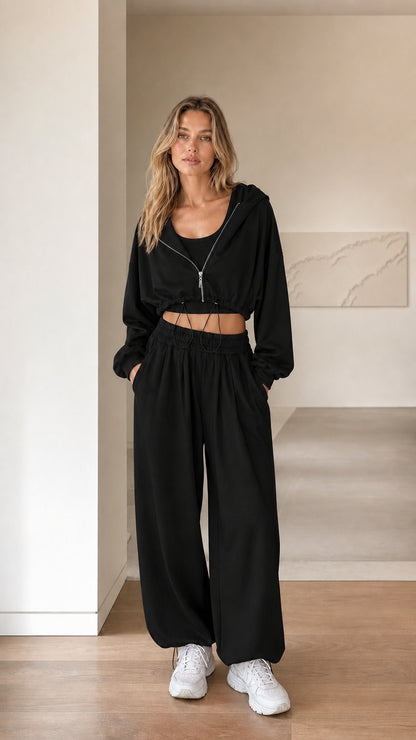 Front view of woman wearing black 3-piece cropped hoodie and sweatpants set