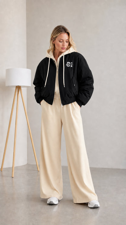 Woman wearing black layered hooded bomber jacket