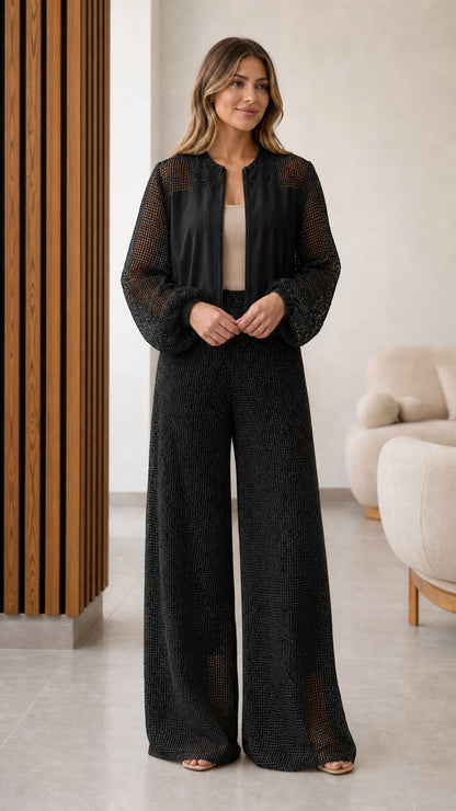 Model wearing black textured mesh panel zip jacket and wide leg pants set