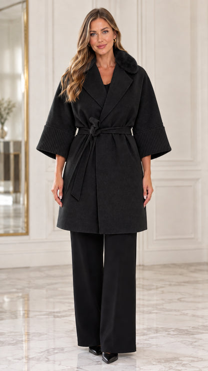 Front view of model wearing the black faux fur collar belted wrap coat