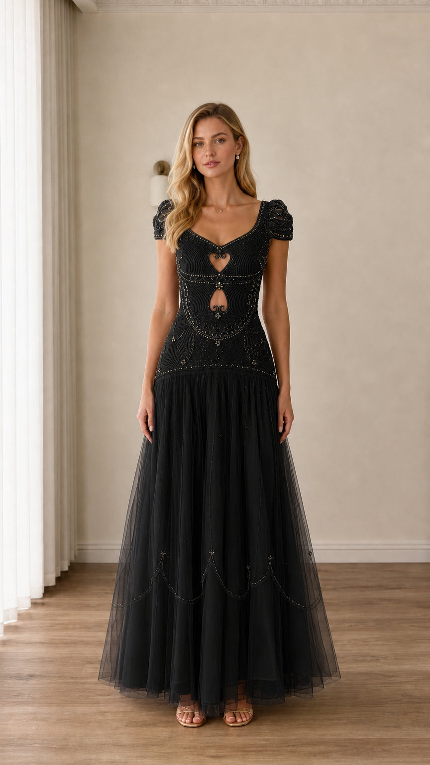 Full-length view of black beaded cap-sleeve cutout tulle evening gown