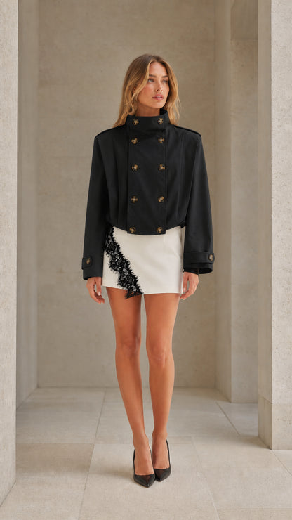 Front view of woman wearing black cropped double-breasted stand collar trench jacket