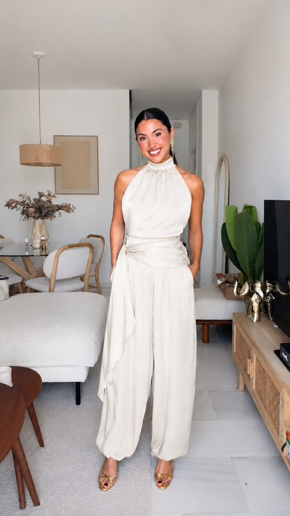 Ivory halter neck jumpsuit with draped waist and relaxed wide-leg silhouette