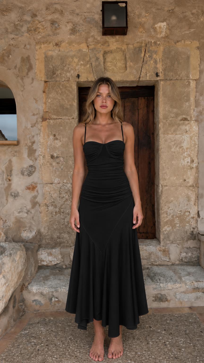 Full-body view of woman in black ruched midi dress