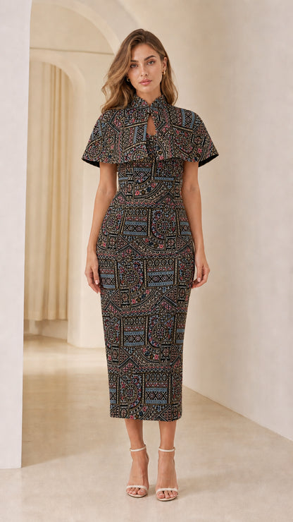 Front view of model wearing Black multi-color embroidered jacquard capelet midi dress