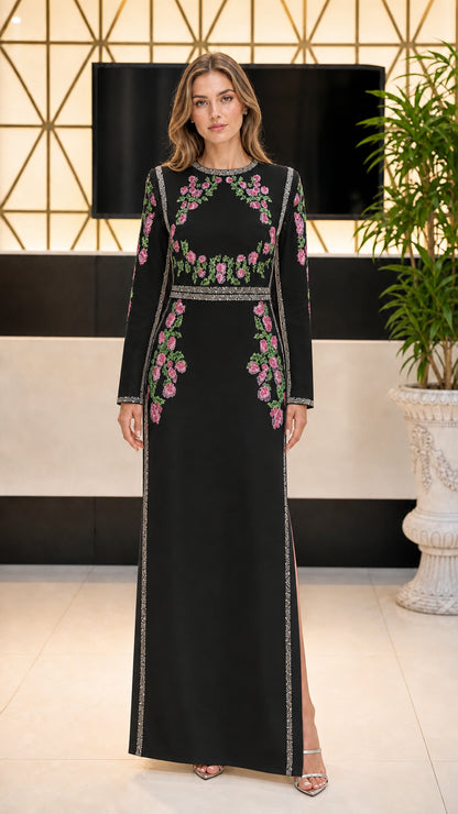 Front view of black long sleeve maxi dress with pink and green floral embroidery and crystal trim
