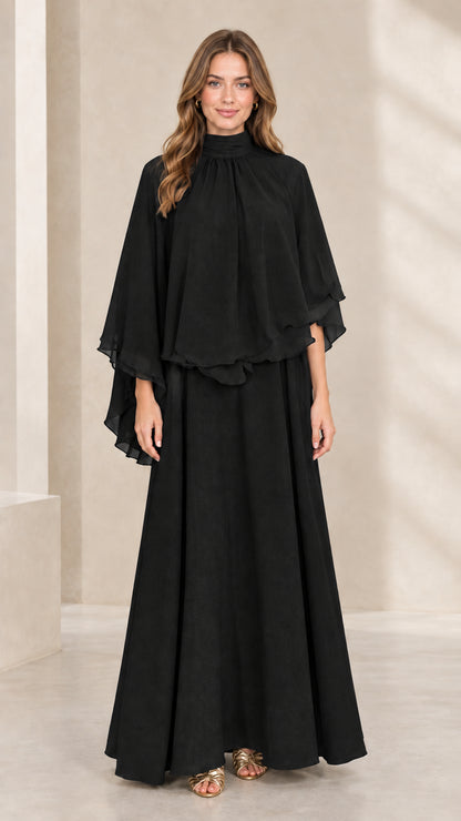 Front view of woman wearing black mock neck capelet maxi dress
