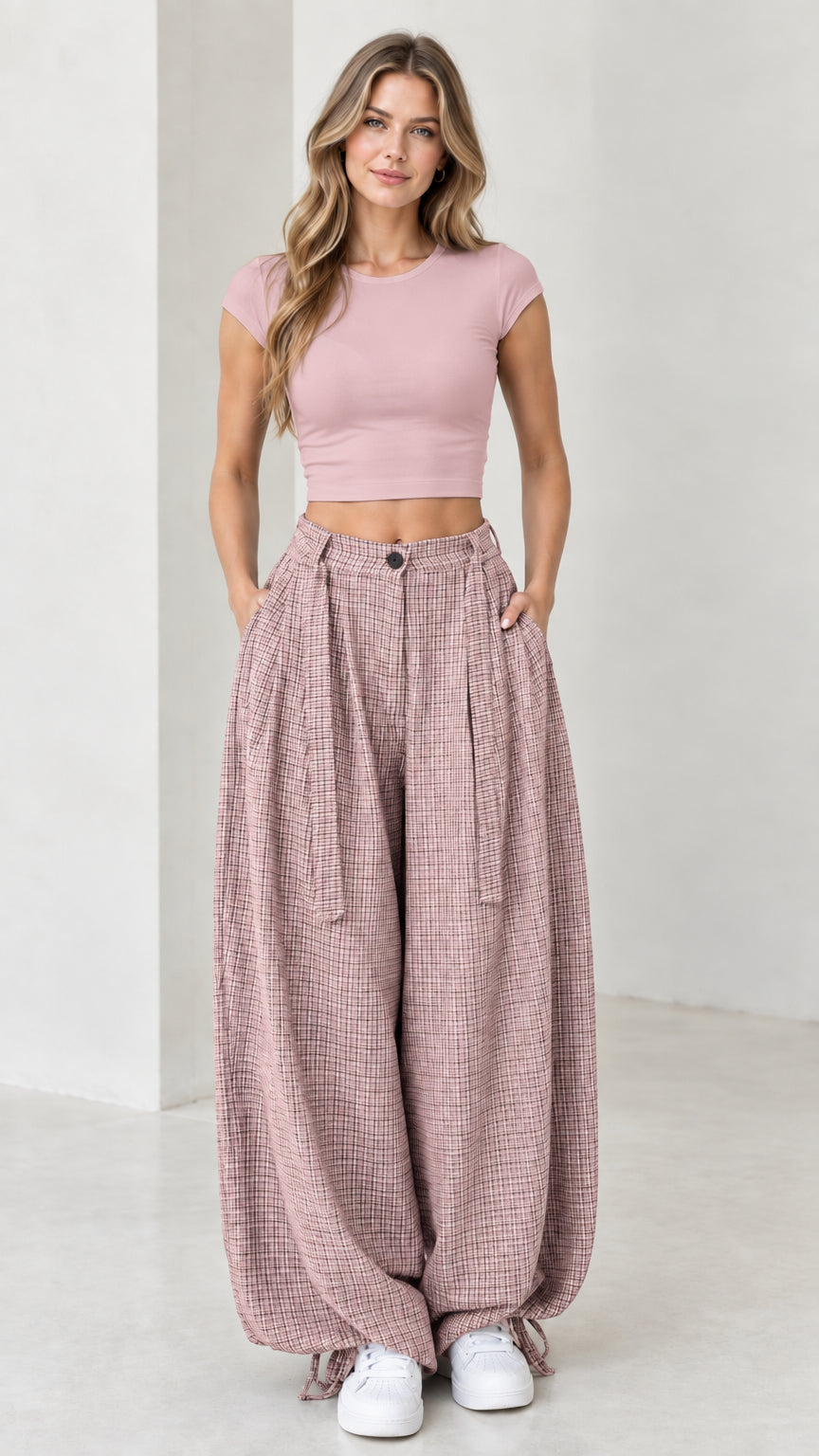 Front view of woman wearing dusty pink micro-plaid pleated wide leg pants