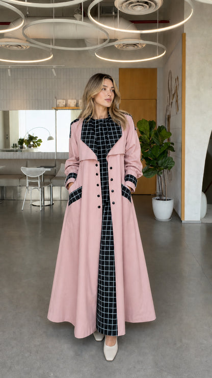 Full front view of model wearing blush pink maxi trench coat with contrast plaid lapels