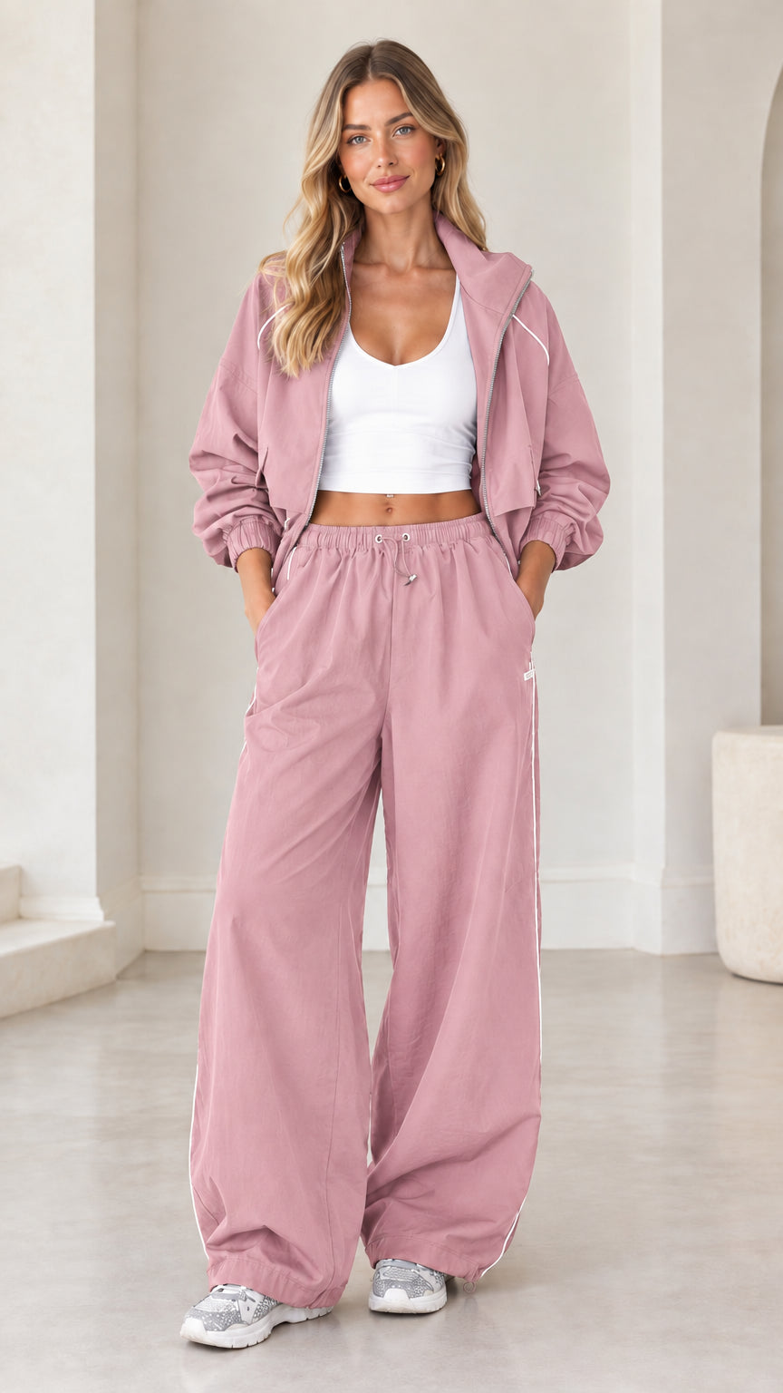 Model wearing dusty pink cropped zip tracksuit two-piece set with wide leg pants