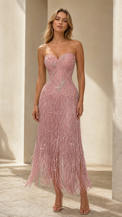 Front view of model wearing blush pink strapless sequin fringe corset midi dress