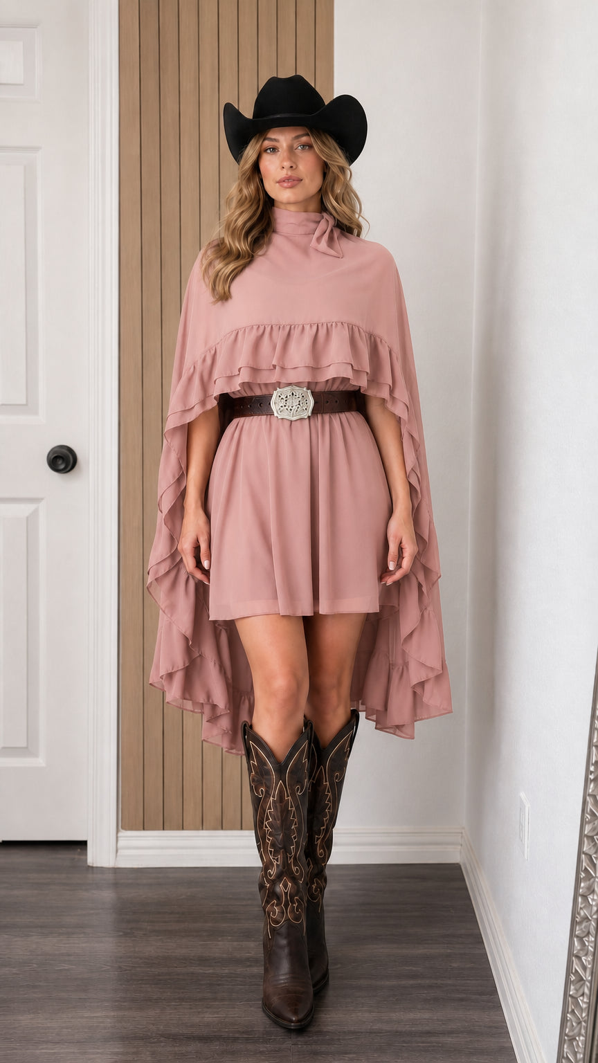 Front view of woman wearing pink mock neck ruffle cape mini dress