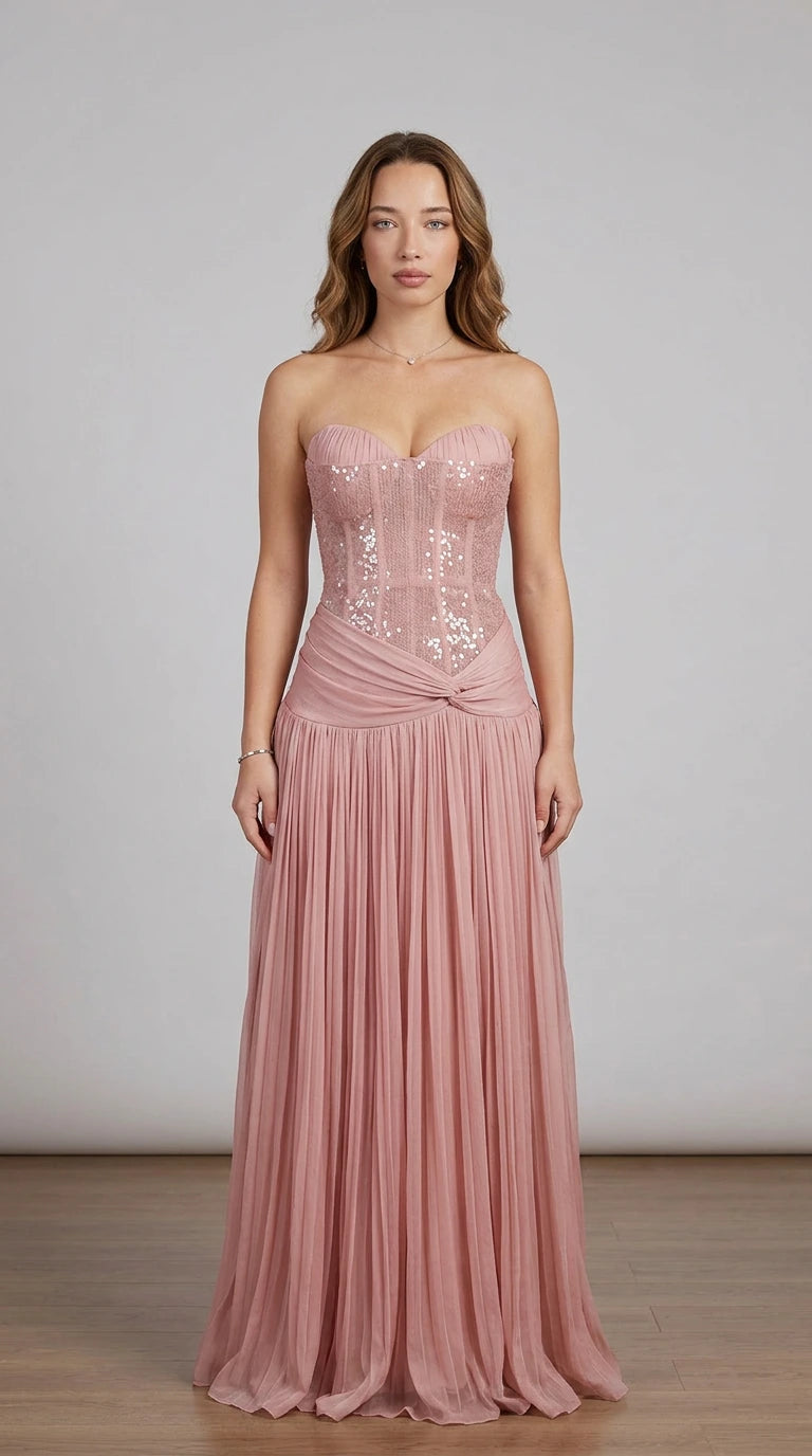 Model wearing dusty rose strapless sequin corset pleated formal dress