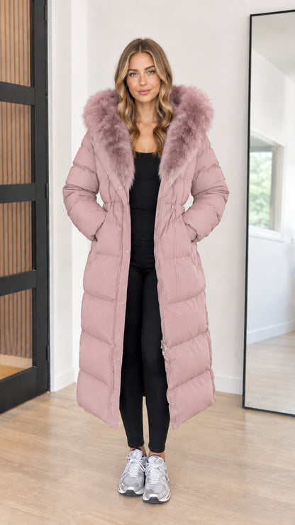 Full length view of women's dusty pink maxi quilted puffer coat with faux fur hood