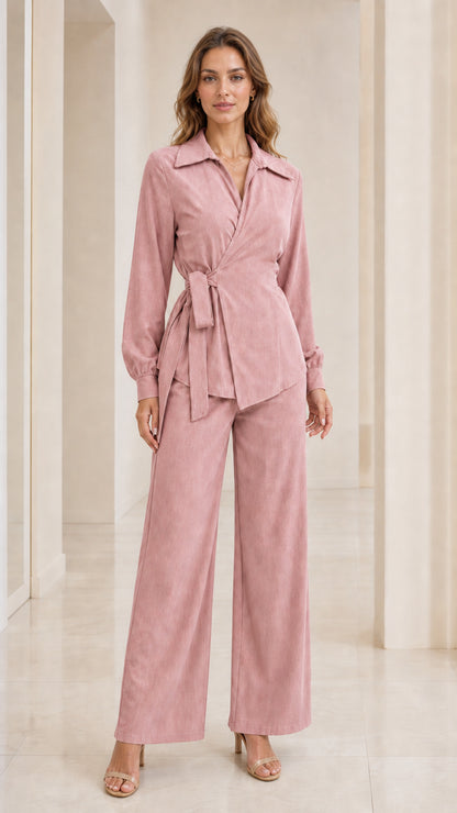 Front view of woman wearing pink wrap blouse and wide-leg trousers