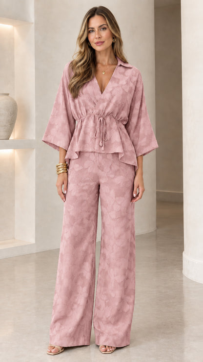 Model wearing dusty pink textured two-piece blouse and wide-leg pants set