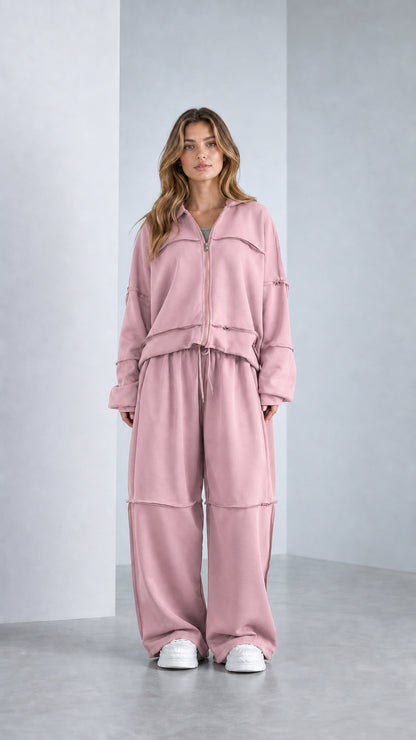 Full-length studio shot of model wearing Dusty Pink exposed seam sweatpants set