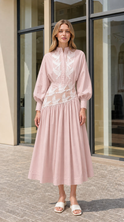 Model wearing blush pink embroidered pleated midi dress with stand collar
