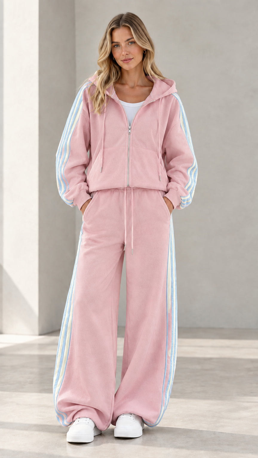 Model wearing dusty pink zip hoodie and matching wide leg pants set with side stripes