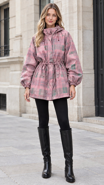 Woman wearing dusty pink plaid hooded drawstring parka jacket with black leggings and boots