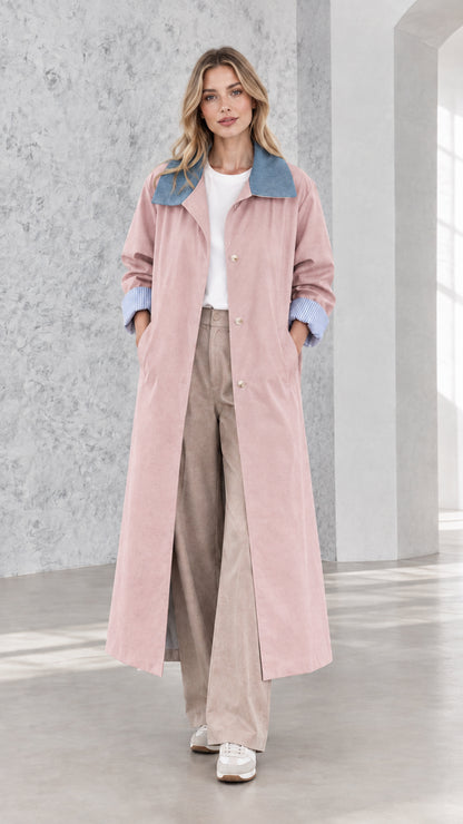 Model wearing dusty pink longline trench coat with blue collar and check cuffs