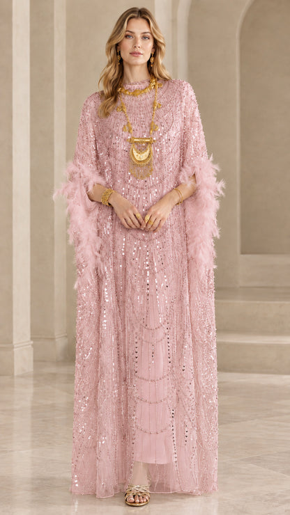 Model wearing blush pink sequin kaftan maxi dress with pink feather trim