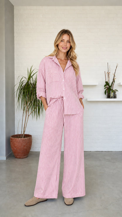 Woman wearing pink striped button-down shirt and wide-leg pants