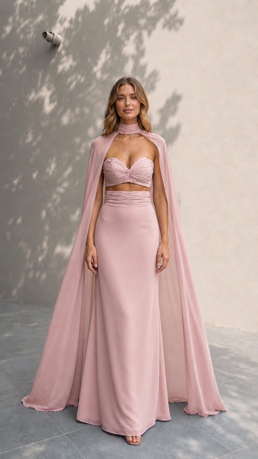 Model wearing dusty rose formal gown with flowing sheer cape