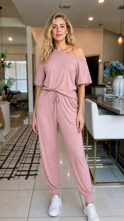 Front view of woman wearing dusty rose off-the-shoulder jumpsuit