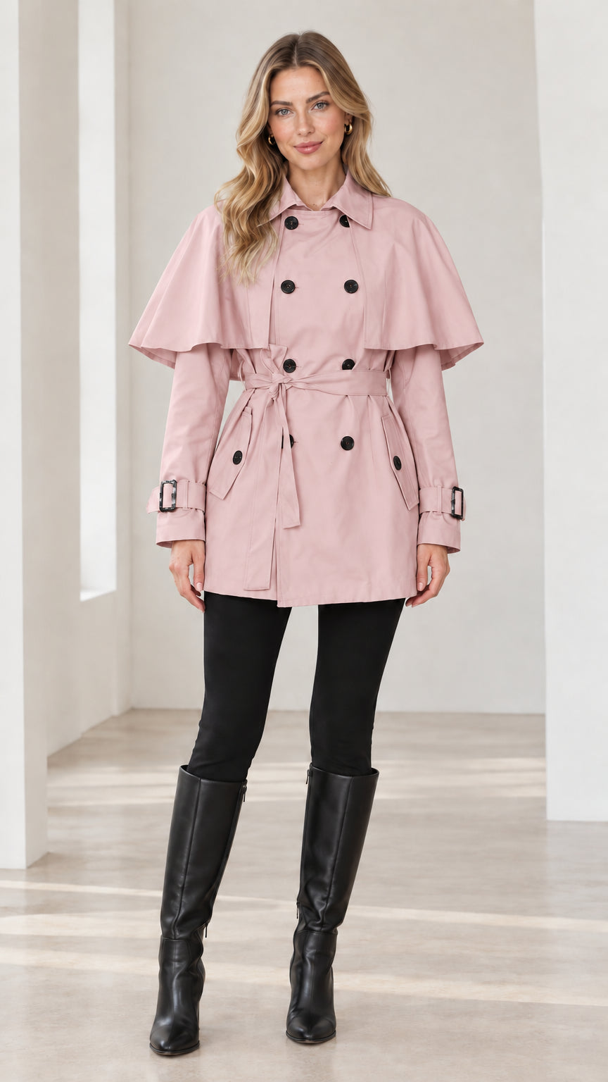 Front full-length view of Blush Pink capelet trench coat with matching belt and contrasting dark buttons