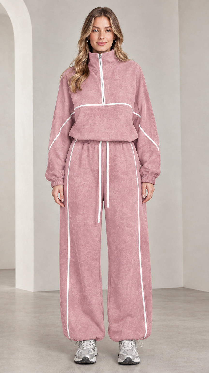Front view of woman wearing dusty pink quarter-zip tracksuit set with white contrast piping