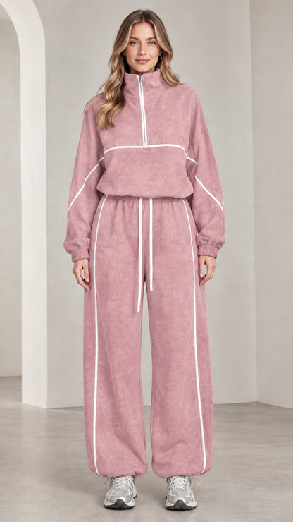 Front view of woman wearing dusty pink quarter-zip tracksuit set with white contrast piping