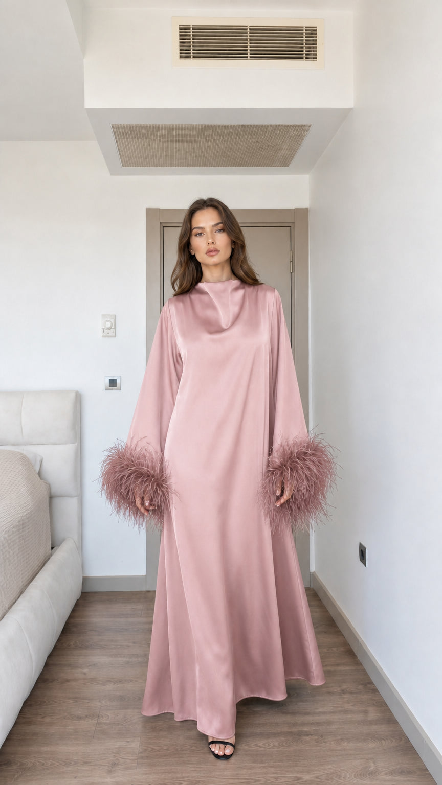 Model wearing dusty pink satin maxi dress with matching feather cuffs
