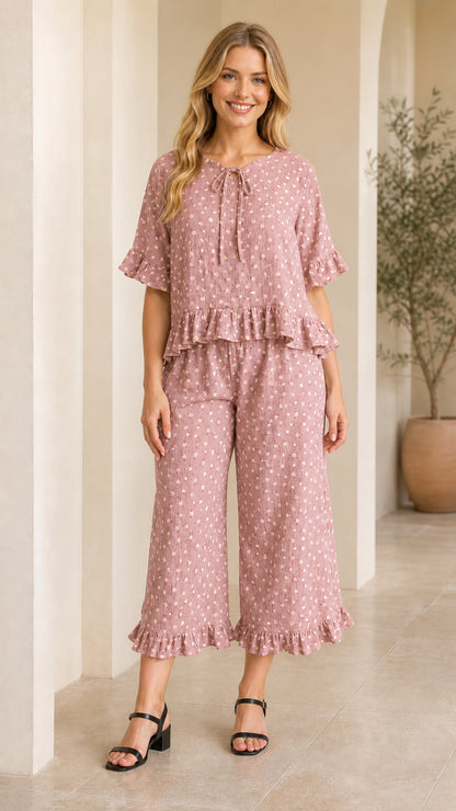 Front view of model wearing dusty pink floral ruffle top and wide-leg pants set