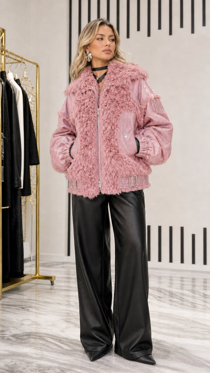 Model posing in dusty pink faux leather and plush shearling bomber jacket