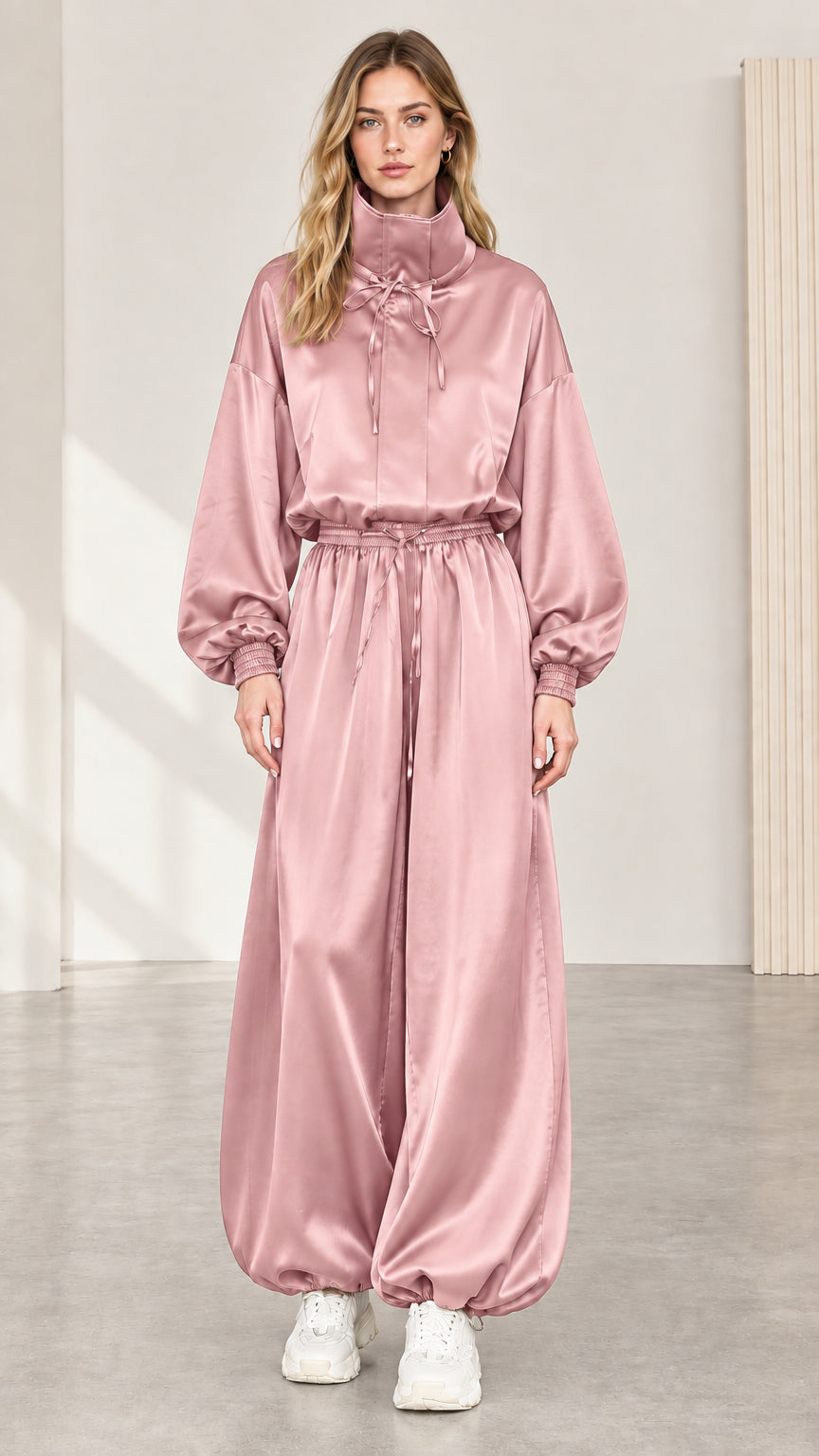 Full front view of model wearing blush pink satin high neck balloon jumpsuit