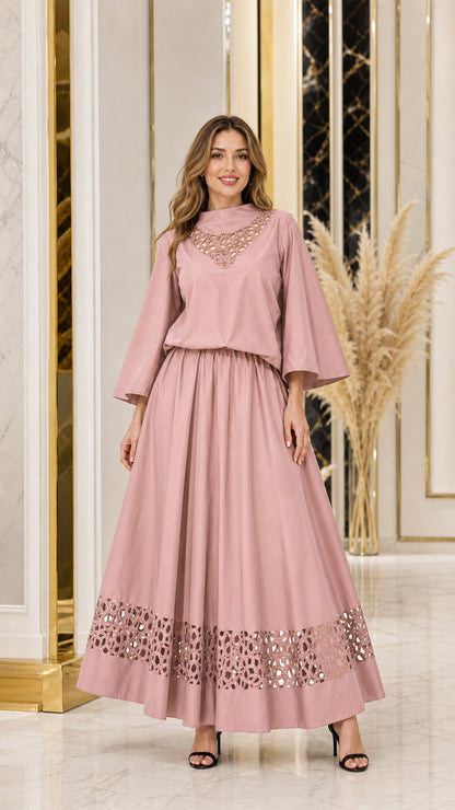 Woman wearing dusty pink cutout neckline top and matching maxi skirt