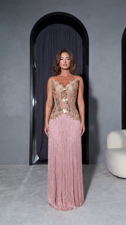 Front view of model wearing Blush Pink strapless maxi gown with gold embellished bodice and pink fringe