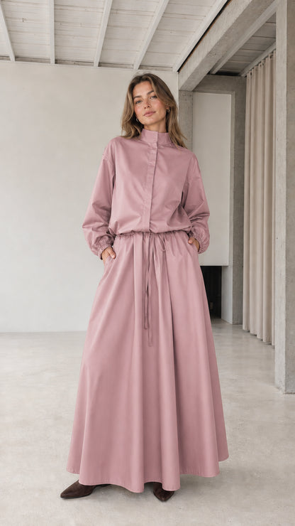 Front full view of woman wearing dusty pink stand collar drawstring maxi dress