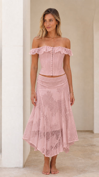 Woman wearing pink off-shoulder lace corset top and midi skirt set