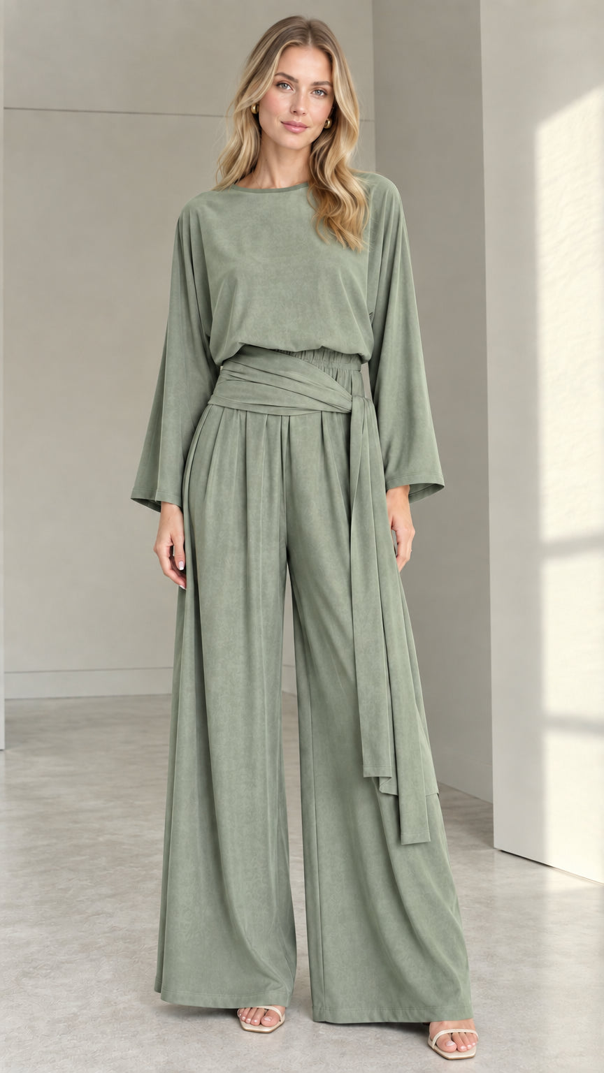 Front full view of woman wearing sage green long-sleeve wide-leg jumpsuit