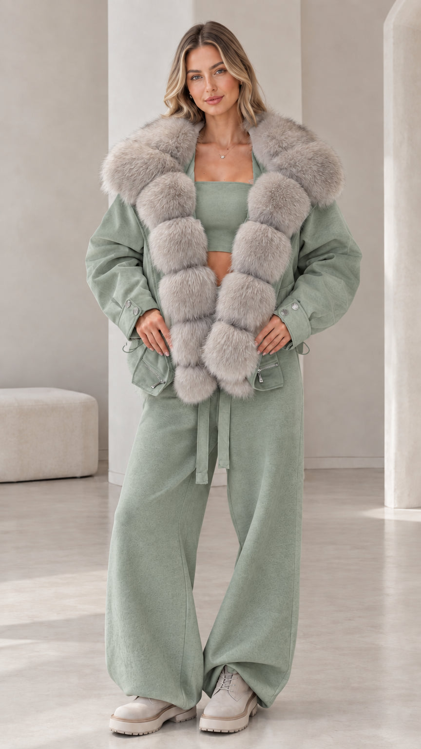 Model wearing sage green jacket and pants set with soft grey faux fur trim