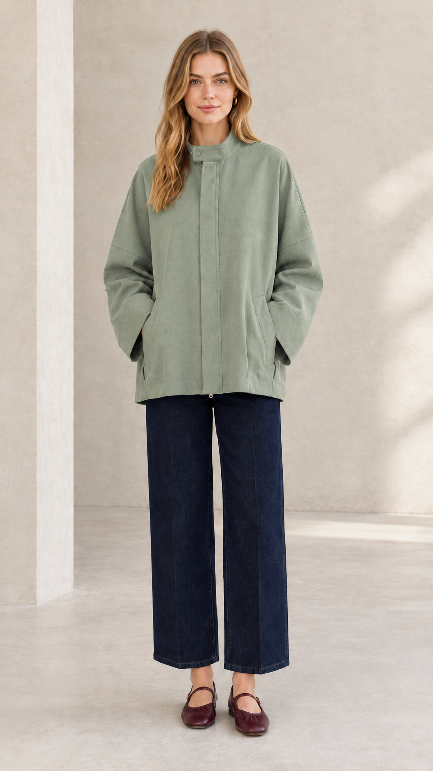 Front view of woman wearing sage green relaxed fit stand collar jacket