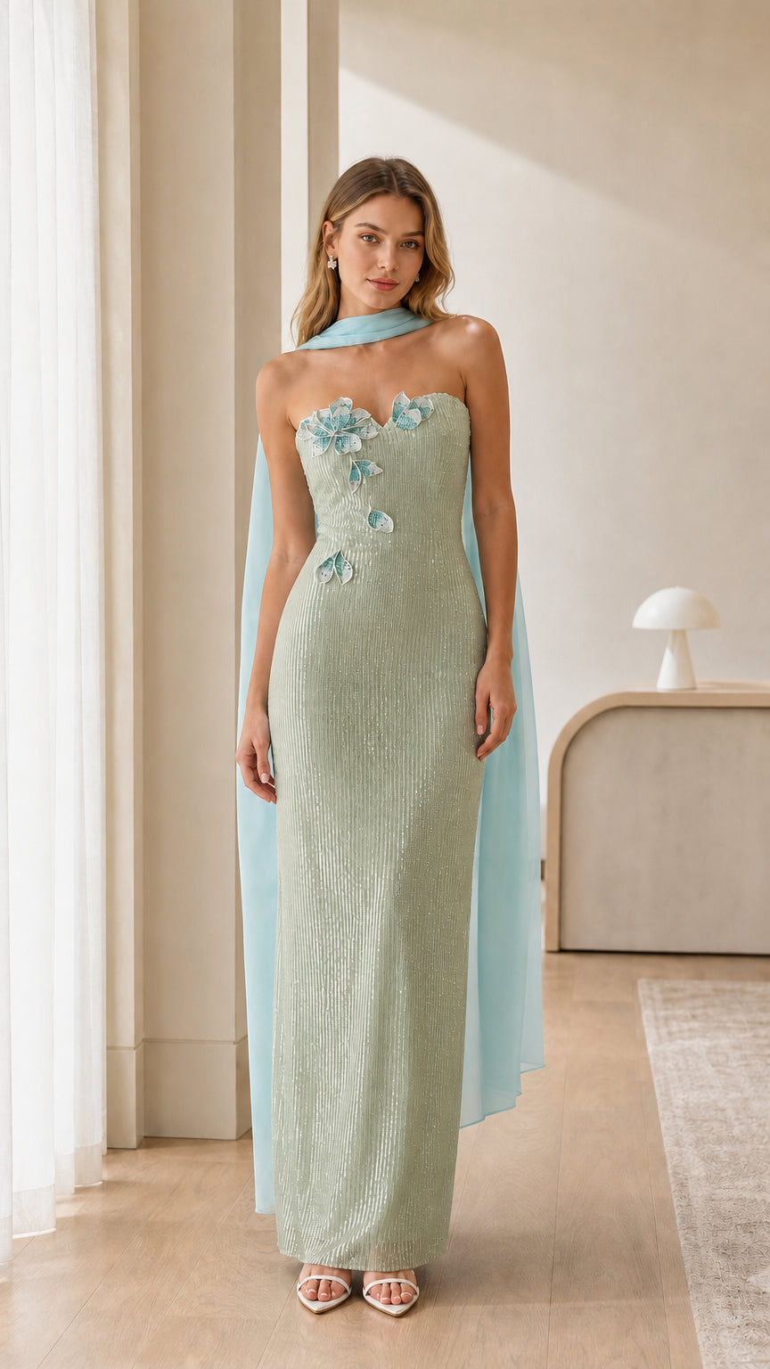 Sage green strapless sequin maxi evening dress with floral accents and draped cape