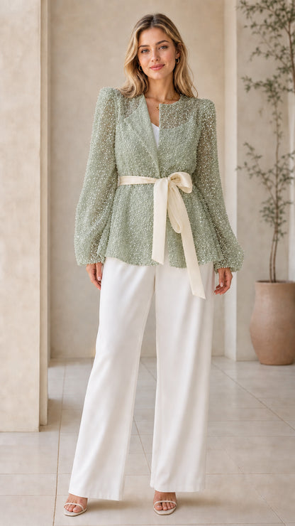 Front view of woman wearing sage green sequin long-sleeve belted jacket