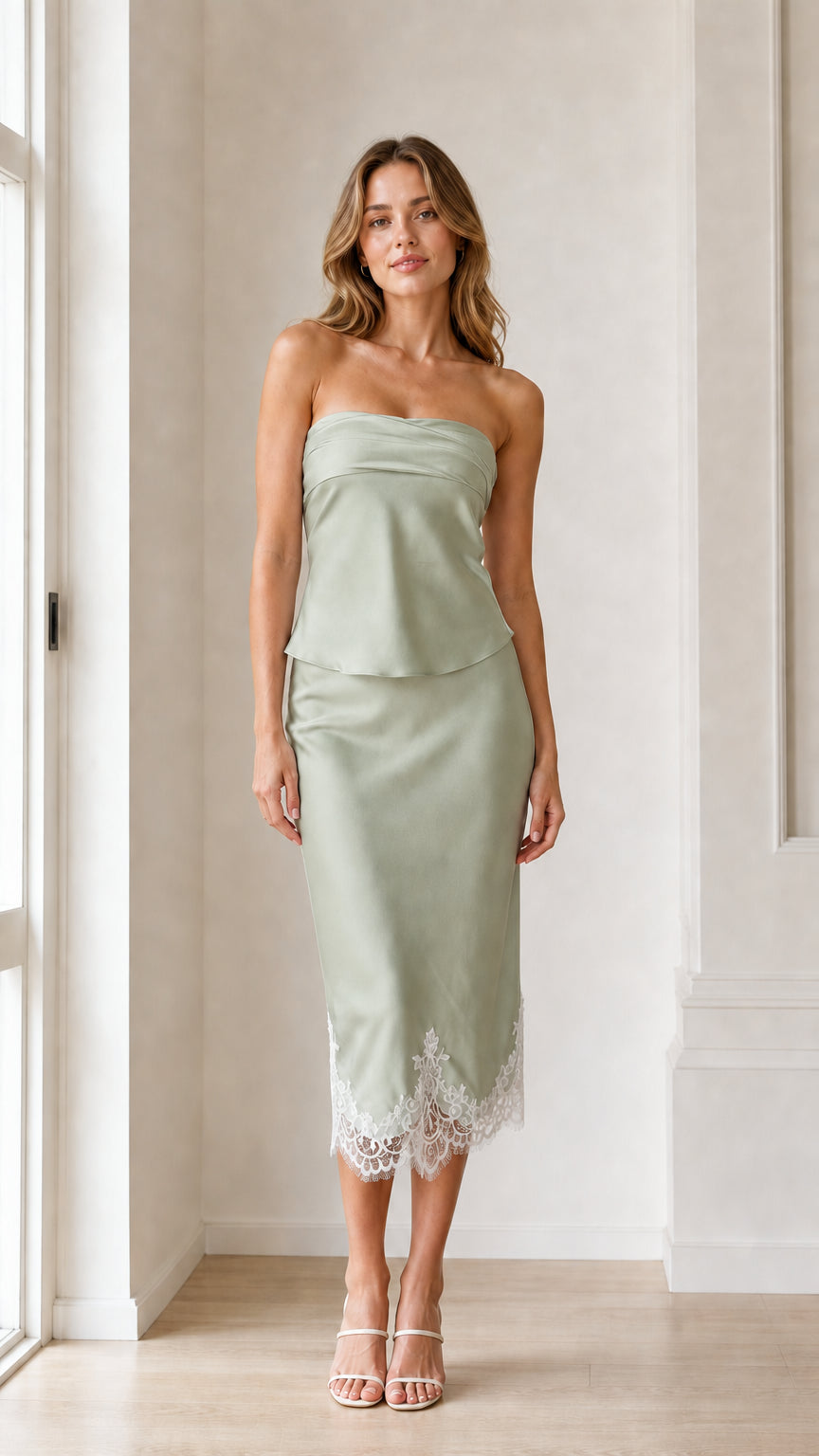 Woman wearing sage green strapless satin midi dress with lace hem