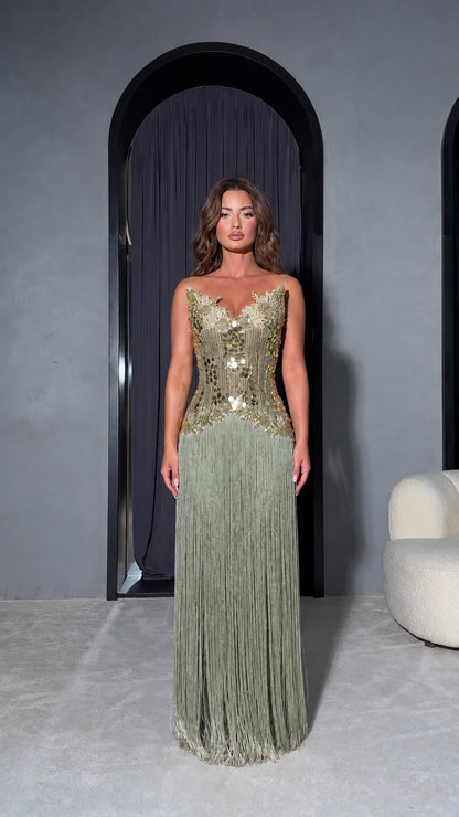 Front view of model wearing Sage Green strapless formal dress with gold sequin bodice and green fringe