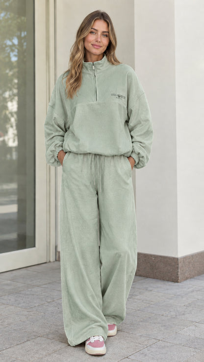 Woman wearing Sage Green fleece quarter-zip pullover and matching wide-leg pants set
