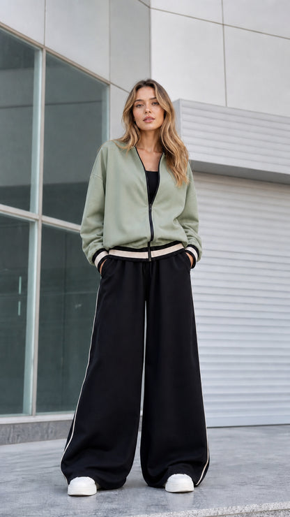 Model wearing sage green zip bomber jacket with black wide leg pants